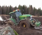 VIDEO - Cum reuseste sa iasa din noroi acest tractor urias