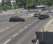  Momentul in care un motociclist din Timisoara este tarat cativa metri, dupa ce s-a lovit de un taxi. Masina s-a rasturnat la marginea drumului
